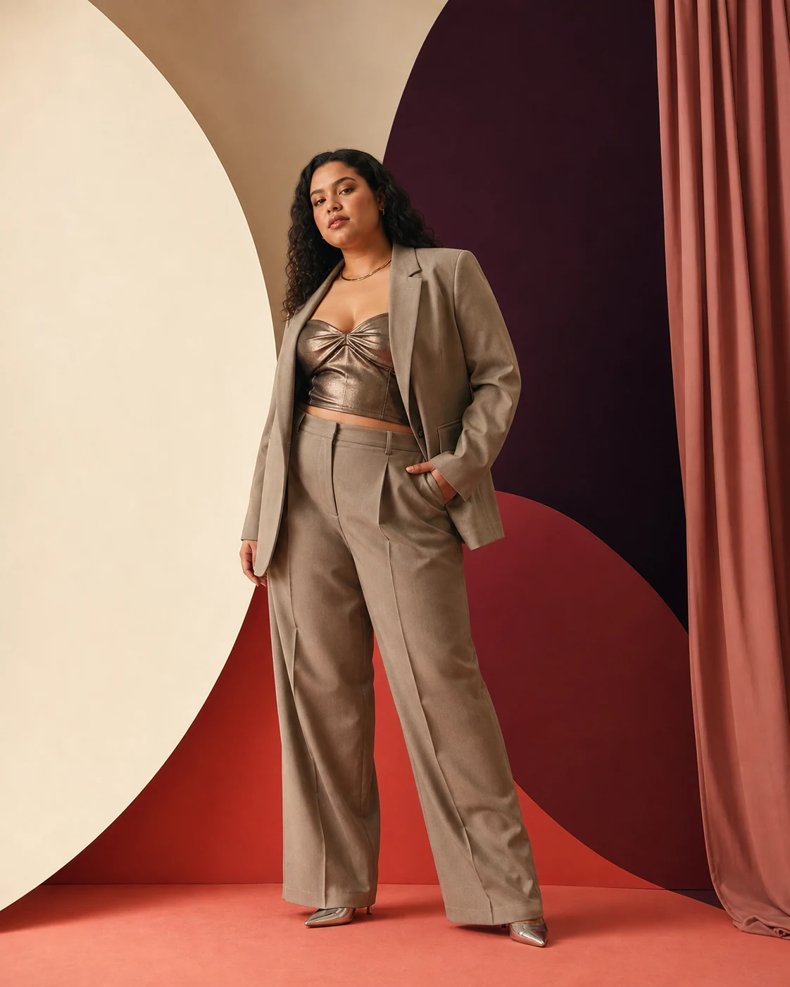 Modella plus-size con completo sartoriale e top metallico