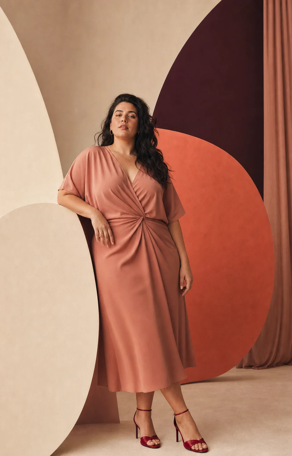Modella plus-size con abito midi rosa cipria