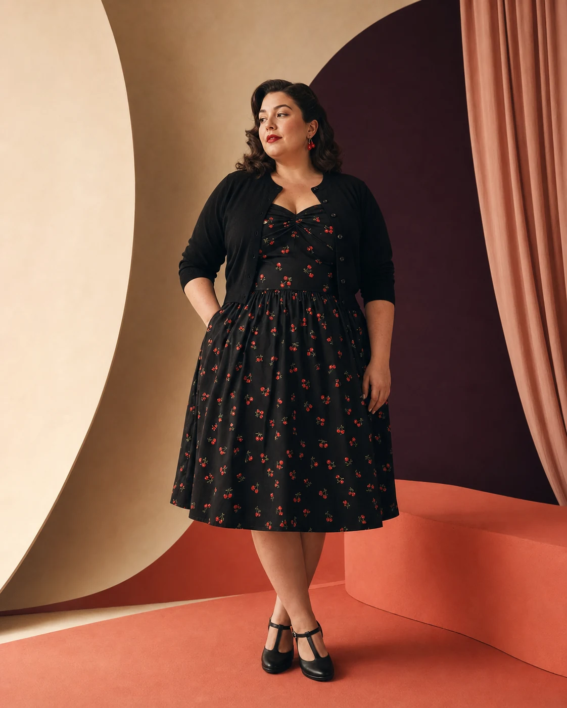 Modella plus-size con abito nero a piccoli motivi rossi