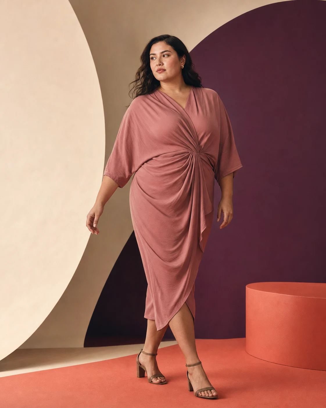 Modella plus-size con abito drappeggiato rosa cipria