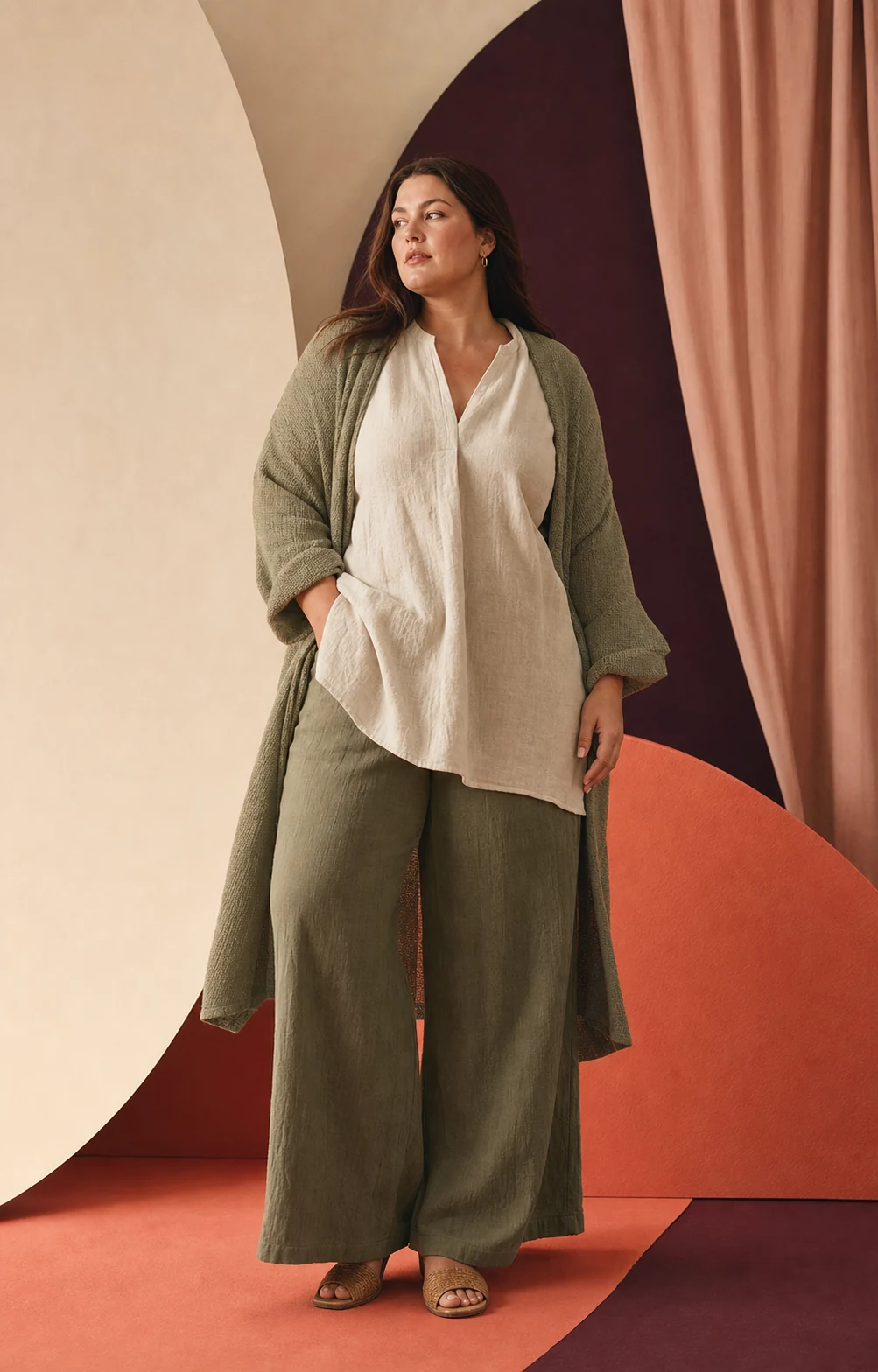 Modella plus-size con tunica chiara e completo verde salvia