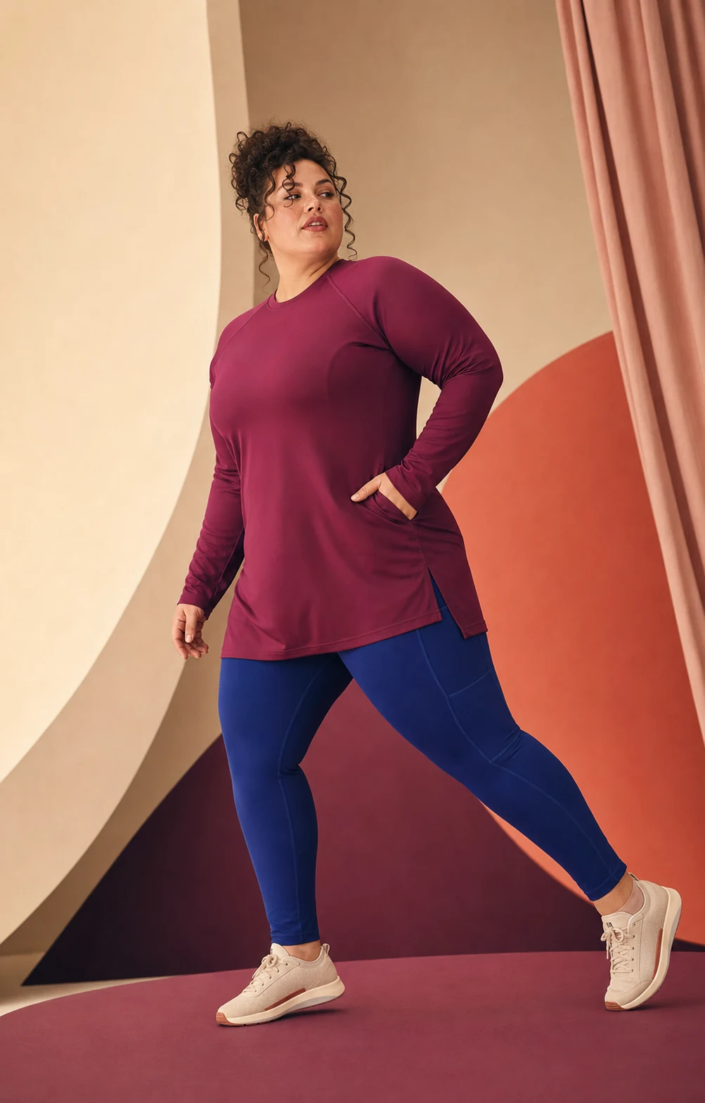 Modella plus-size in movimento con completo sportivo prugna e blu