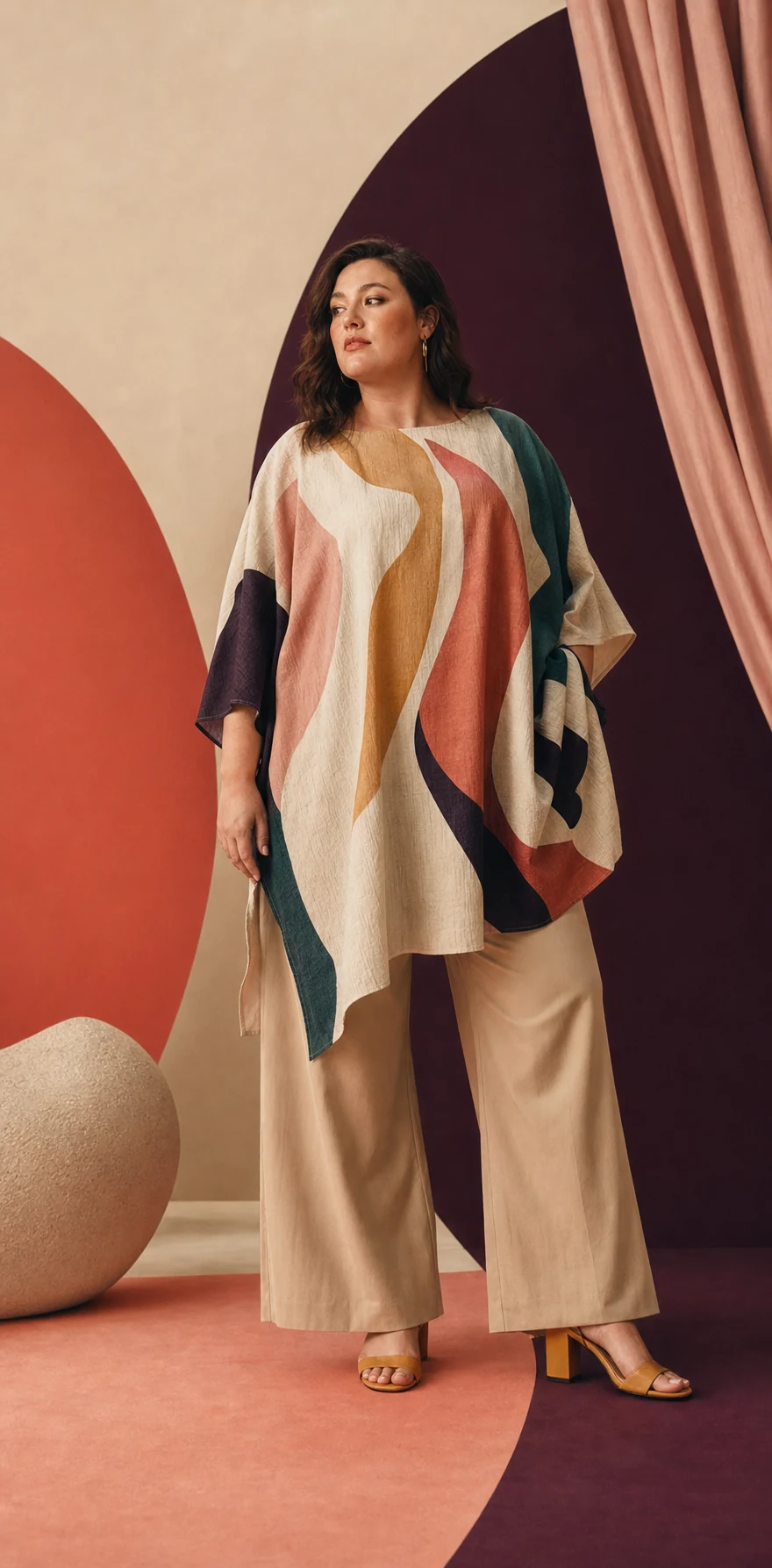 Modella plus-size con tunica grafica e pantaloni chiari