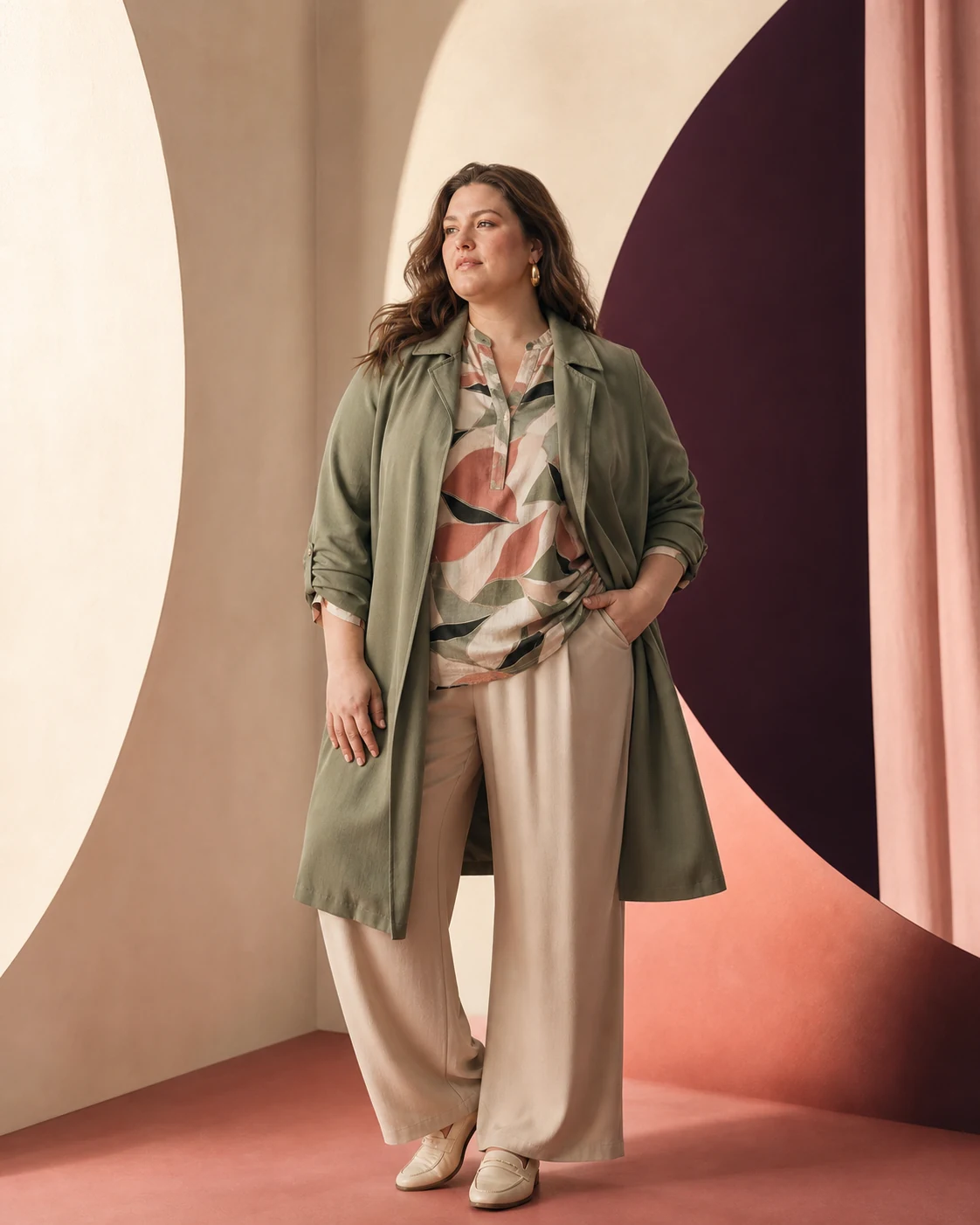 Modella plus-size con soprabito verde salvia e blusa fantasia