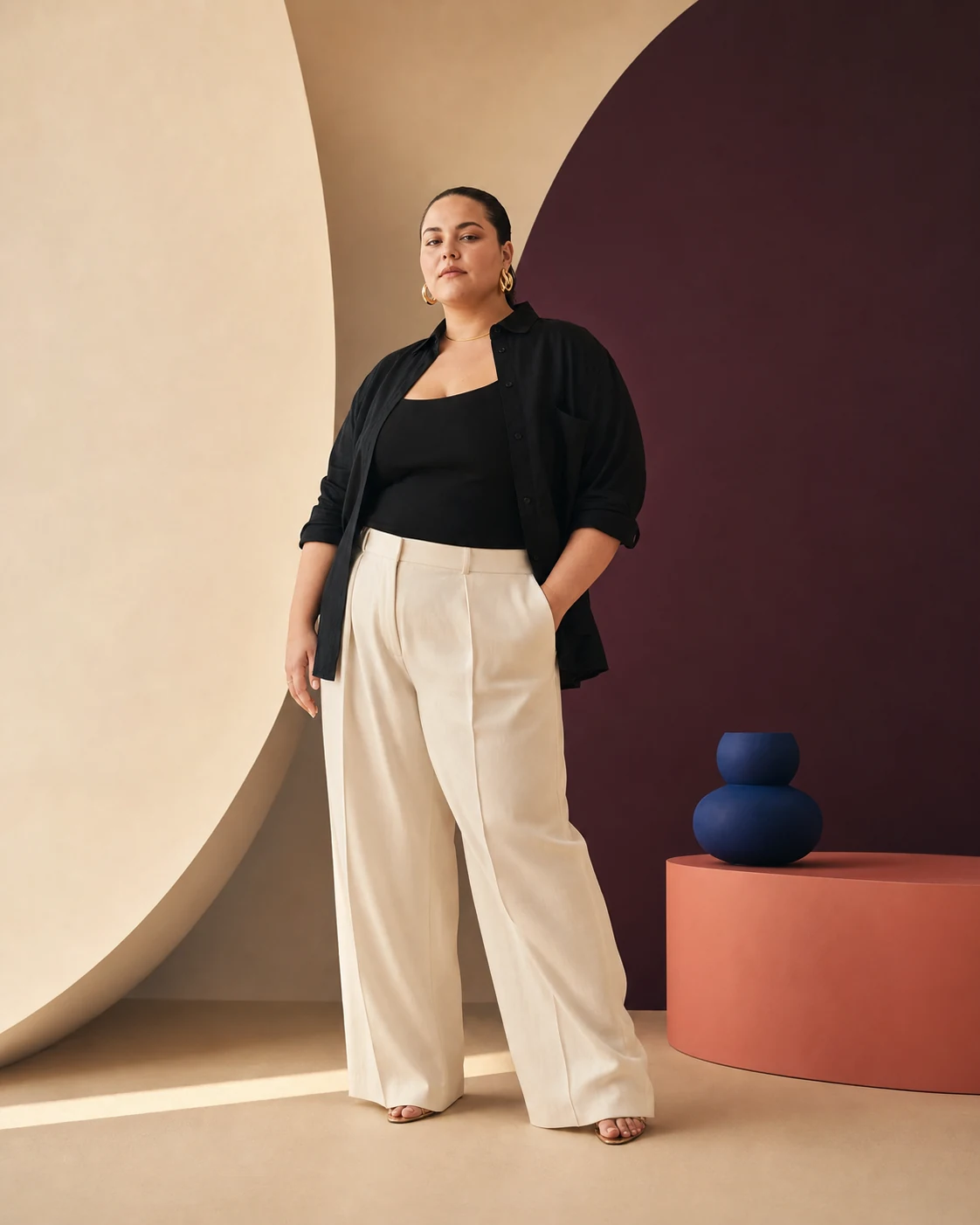 Modella plus-size con separati neri e avorio in un set architettonico